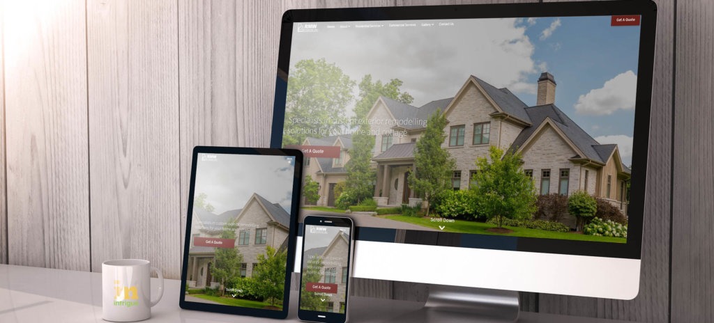 A computer, tablet, and phone display a house image on a website. A white mug labeled "JM" stands next to the devices on a desk.