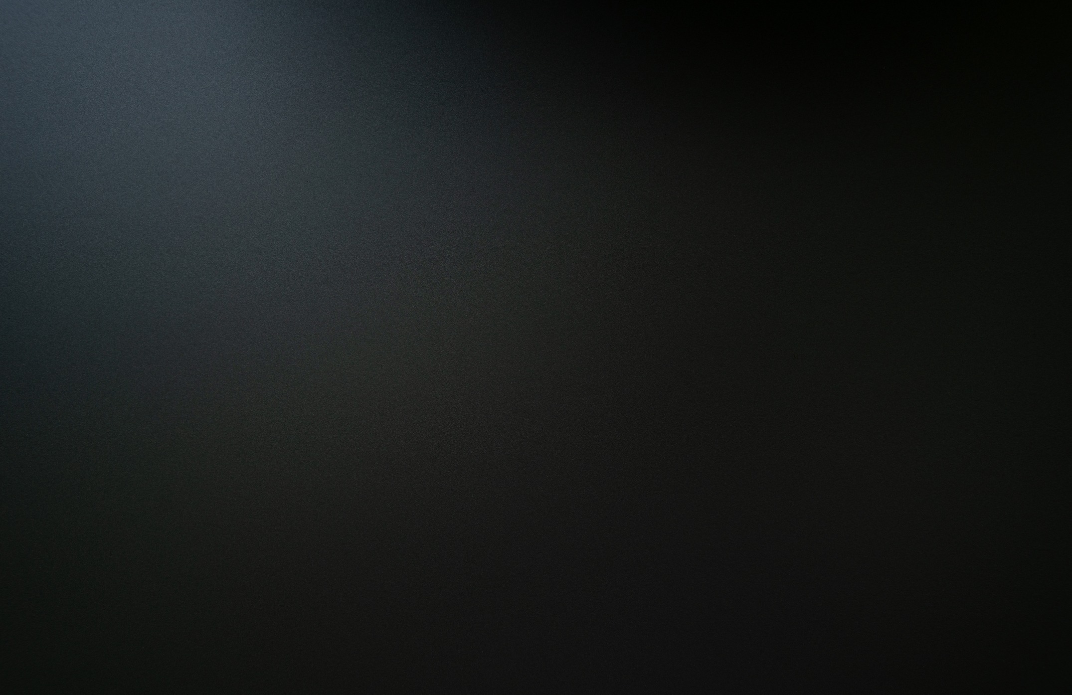 The texture of the dark black carbon slab is illuminated from the top.